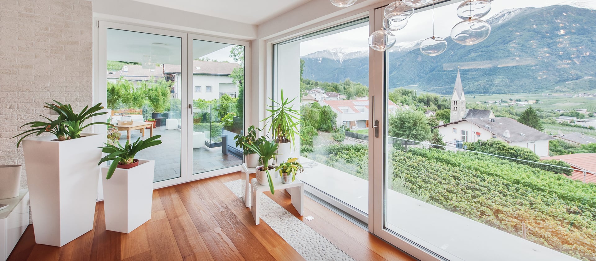 Wohnraum mit bodentiefen Finstral Fenstertüren und Blick ins Grüne